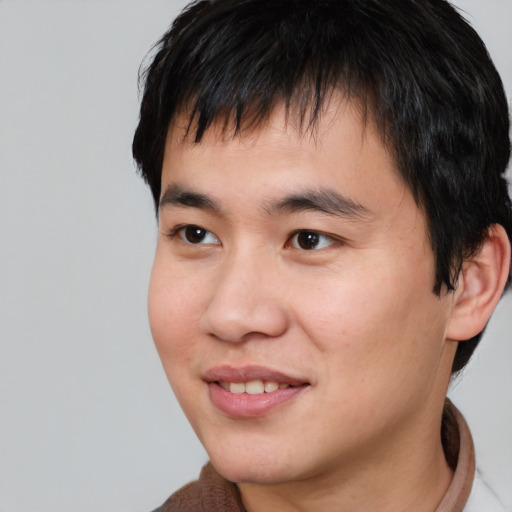 Joyful asian young-adult male with short  brown hair and brown eyes