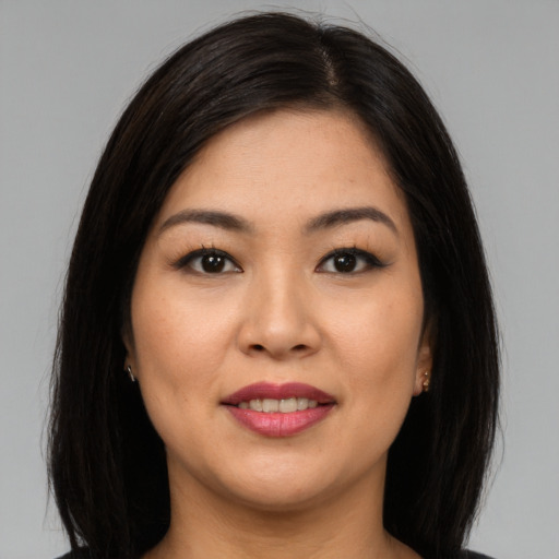 Joyful asian young-adult female with long  brown hair and brown eyes