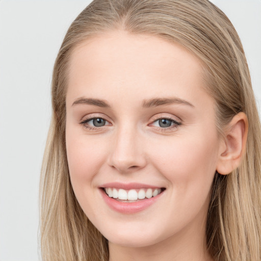 Joyful white young-adult female with long  brown hair and blue eyes