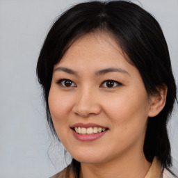 Joyful asian young-adult female with medium  black hair and brown eyes