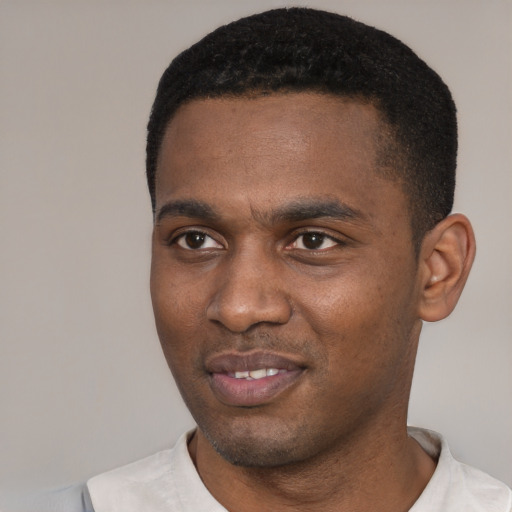 Joyful black young-adult male with short  black hair and brown eyes
