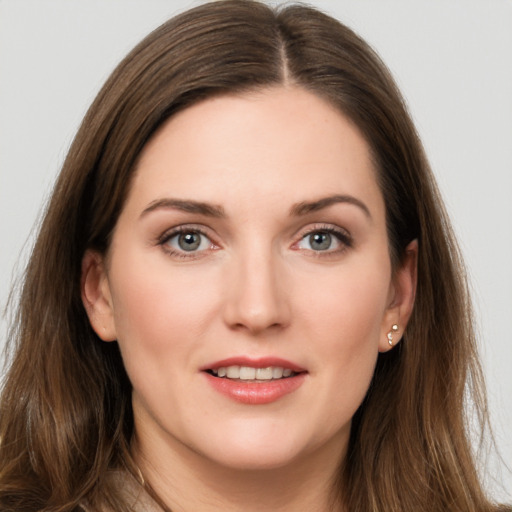 Joyful white young-adult female with long  brown hair and grey eyes