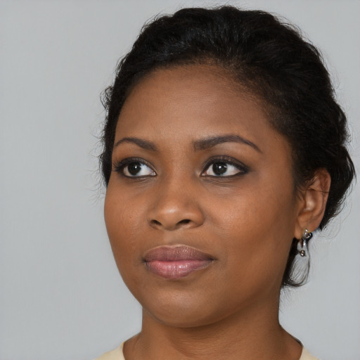 Joyful black young-adult female with medium  brown hair and brown eyes