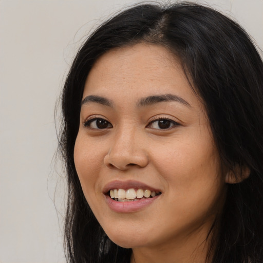 Joyful asian young-adult female with long  black hair and brown eyes