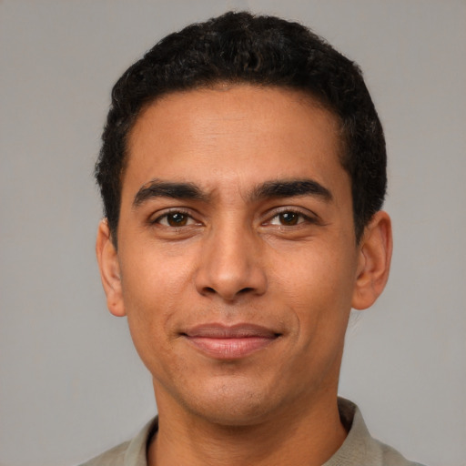 Joyful latino young-adult male with short  brown hair and brown eyes