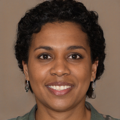Joyful black young-adult female with long  brown hair and brown eyes