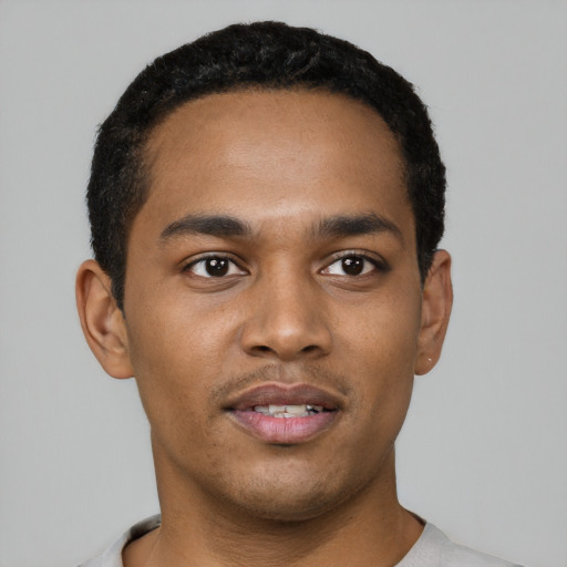 Joyful black young-adult male with short  black hair and brown eyes