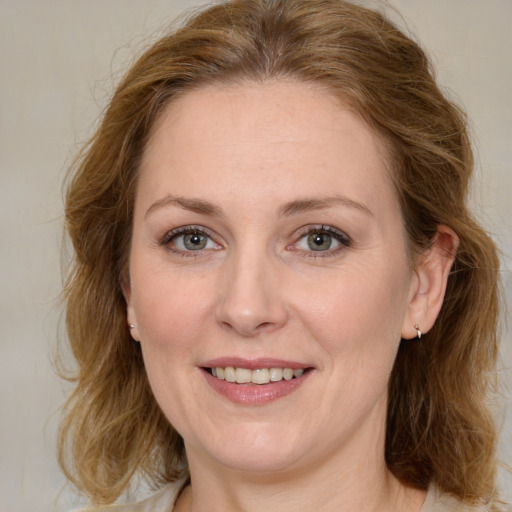 Joyful white young-adult female with medium  brown hair and green eyes