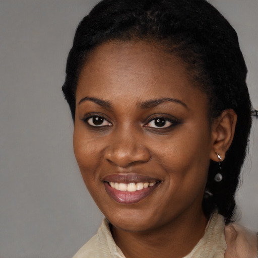 Joyful black young-adult female with short  black hair and brown eyes