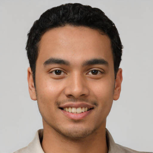 Joyful latino young-adult male with short  black hair and brown eyes