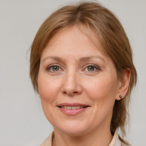 Joyful white adult female with medium  brown hair and blue eyes