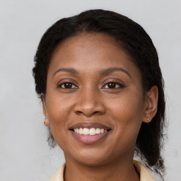 Joyful black adult female with medium  brown hair and brown eyes