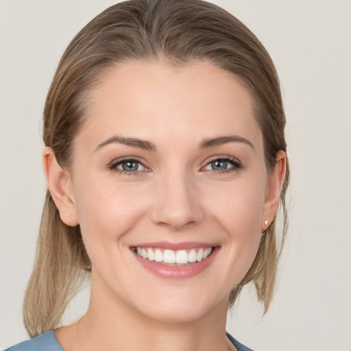 Joyful white young-adult female with medium  brown hair and grey eyes