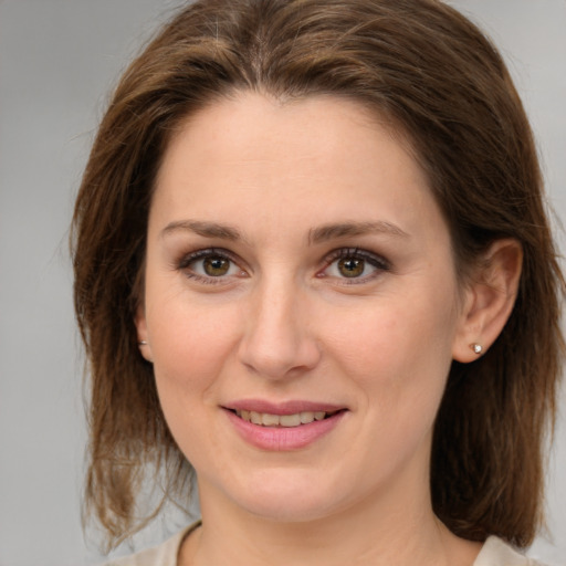 Joyful white young-adult female with medium  brown hair and green eyes