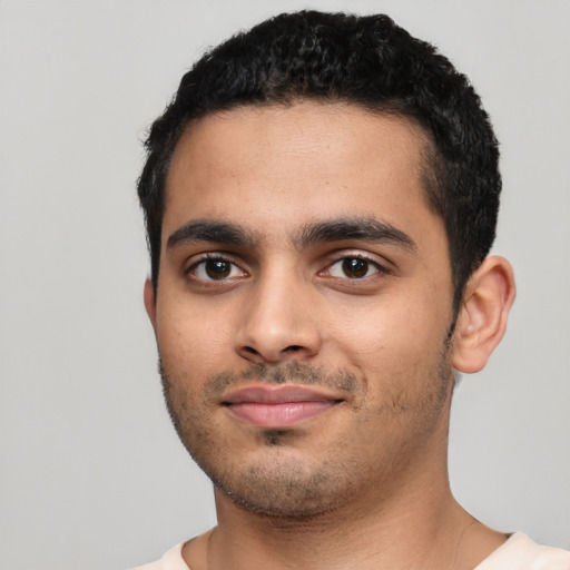 Joyful latino young-adult male with short  black hair and brown eyes