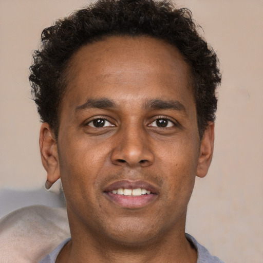 Joyful latino young-adult male with short  brown hair and brown eyes