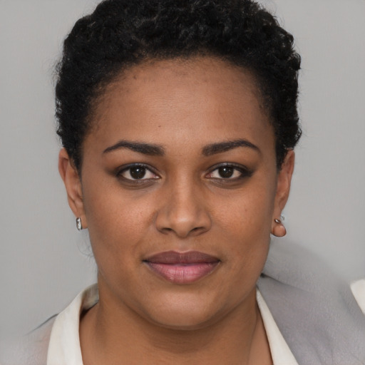 Joyful black young-adult female with short  brown hair and brown eyes