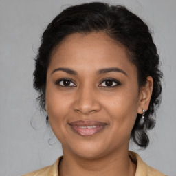 Joyful black young-adult female with medium  brown hair and brown eyes