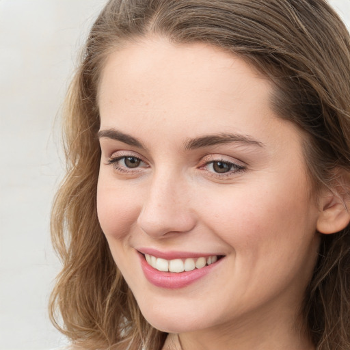 Joyful white young-adult female with long  brown hair and green eyes