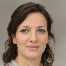 Joyful white young-adult female with medium  brown hair and green eyes