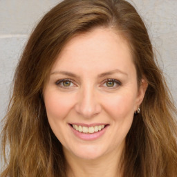 Joyful white young-adult female with long  brown hair and green eyes