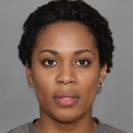 Joyful black young-adult female with short  brown hair and brown eyes