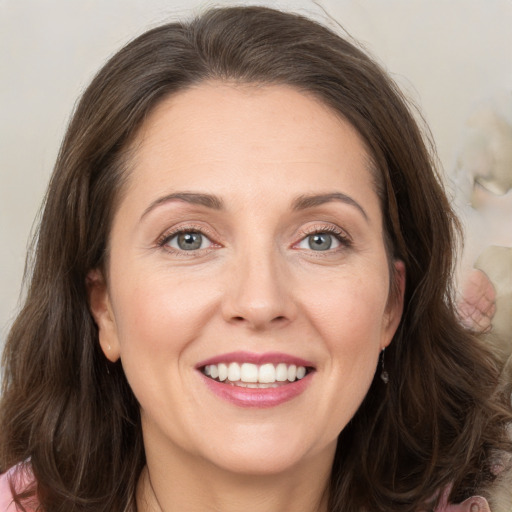 Joyful white adult female with medium  brown hair and grey eyes