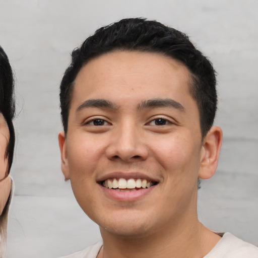 Joyful white young-adult male with short  black hair and brown eyes