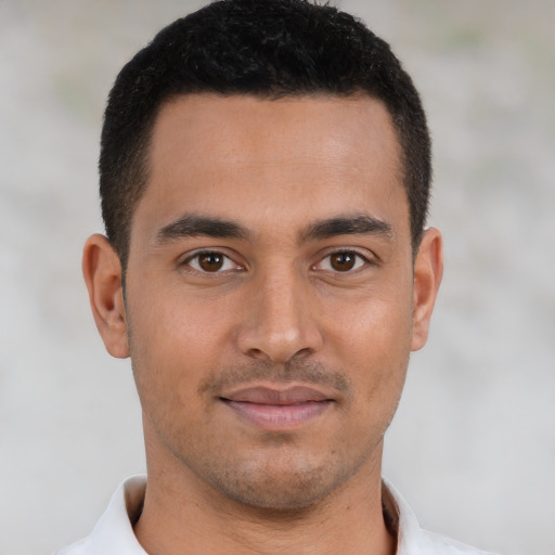 Joyful latino young-adult male with short  brown hair and brown eyes