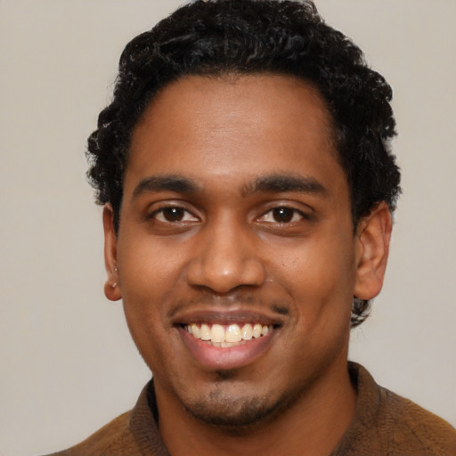 Joyful black young-adult male with short  black hair and brown eyes