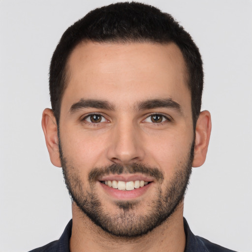 Joyful white young-adult male with short  black hair and brown eyes