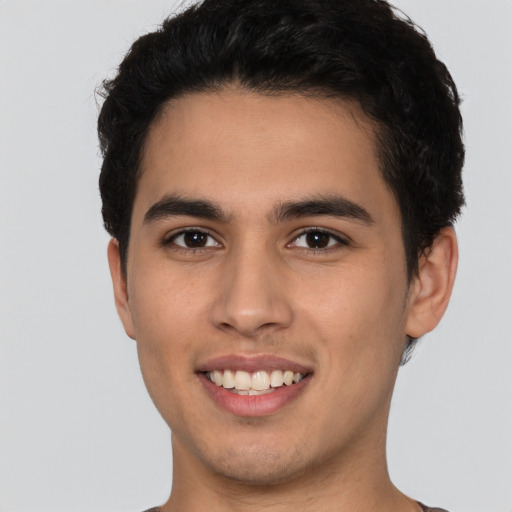 Joyful white young-adult male with short  black hair and brown eyes