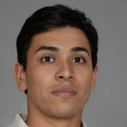 Joyful latino young-adult male with short  brown hair and brown eyes