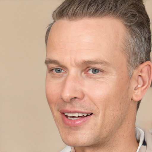 Joyful white adult male with short  brown hair and brown eyes