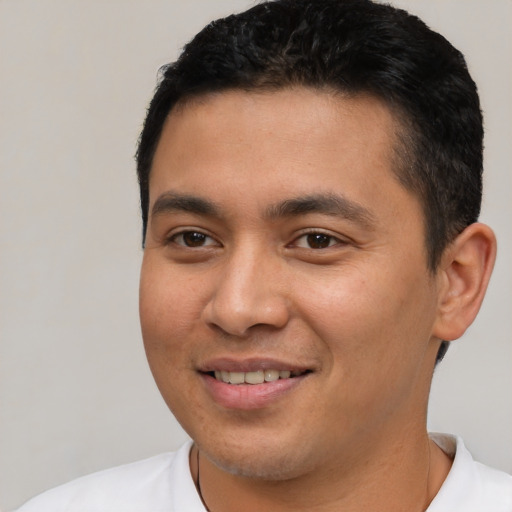 Joyful latino young-adult male with short  brown hair and brown eyes