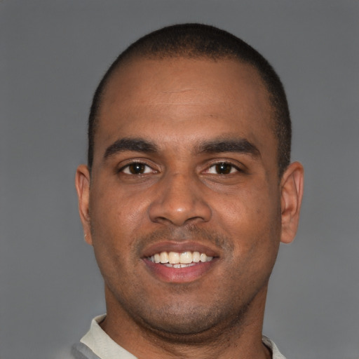 Joyful black young-adult male with short  brown hair and brown eyes