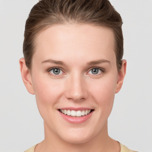 Joyful white young-adult female with short  brown hair and grey eyes