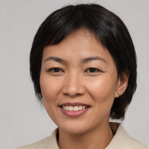 Joyful asian adult female with medium  brown hair and brown eyes