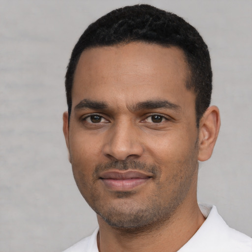 Joyful black young-adult male with short  black hair and brown eyes