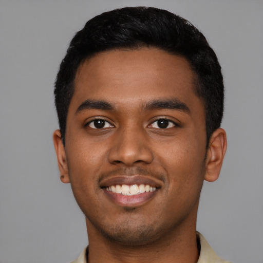 Joyful black young-adult male with short  black hair and brown eyes