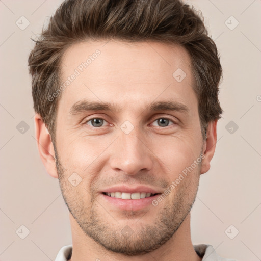 Joyful white young-adult male with short  brown hair and grey eyes