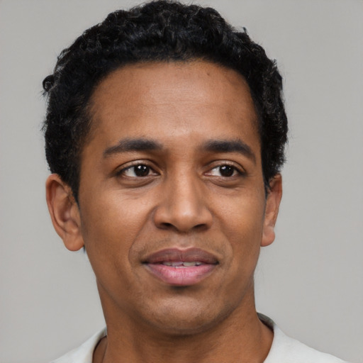 Joyful black young-adult male with short  black hair and brown eyes