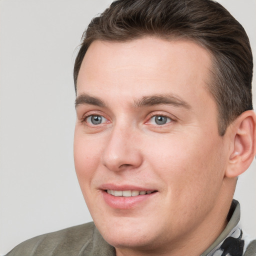 Joyful white young-adult male with short  brown hair and grey eyes