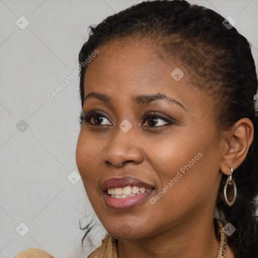 Joyful black young-adult female with long  brown hair and brown eyes