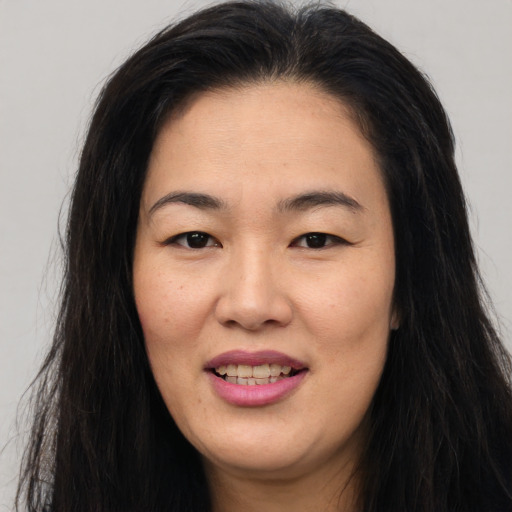 Joyful asian young-adult female with long  brown hair and brown eyes