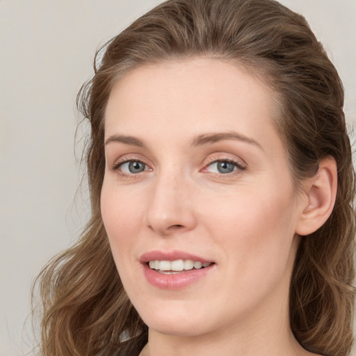 Joyful white young-adult female with medium  brown hair and blue eyes