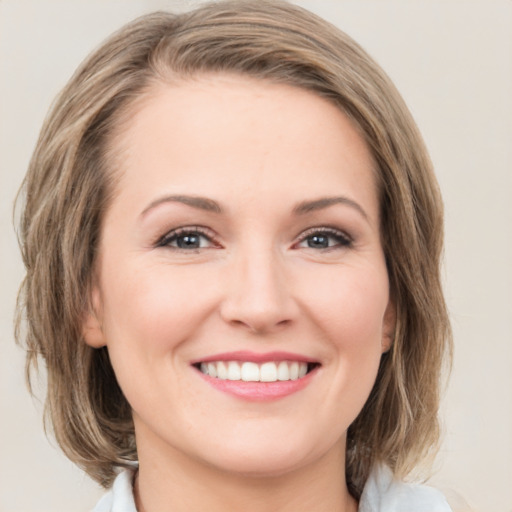 Joyful white young-adult female with medium  brown hair and green eyes