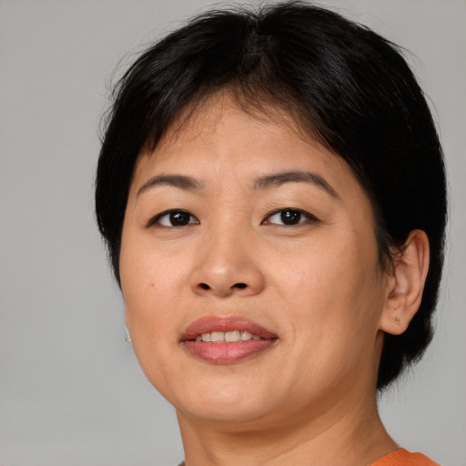 Joyful asian adult female with medium  brown hair and brown eyes