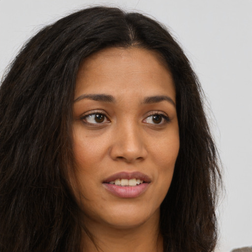 Joyful latino young-adult female with long  brown hair and brown eyes