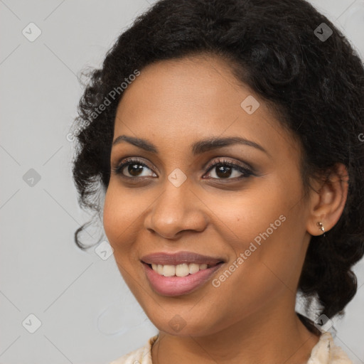 Joyful black young-adult female with long  brown hair and brown eyes